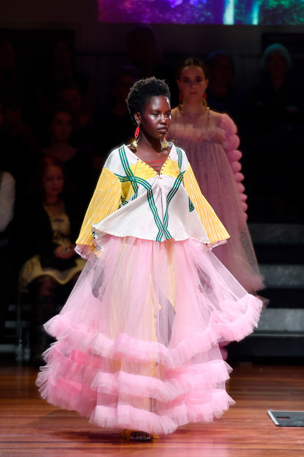 Model wearing layered pink tulle skirt and white and yellow blouse